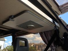 the inside of a vehicle with its door open and curtains pulled up to reveal an overhead light