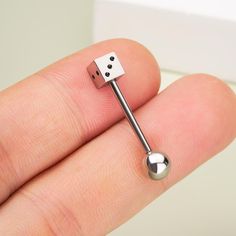 a person holding a tiny metal object in their left hand, with the tip sticking out of it