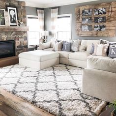 a living room with a large sectional couch and rug on the floor in front of a fireplace