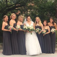 a group of women standing next to each other holding bouquets in their hands and posing for the camera