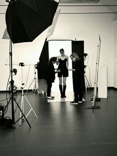 black and white photograph of three people in front of a camera set up for a photo shoot