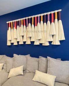 a living room with blue walls and white pillows on the couches is decorated with colorful tassels