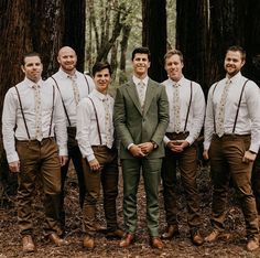 a group of men standing next to each other in front of trees