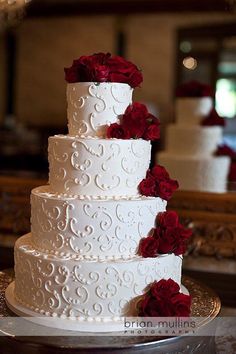 a white wedding cake with red roses on it and the words bridal written in spanish