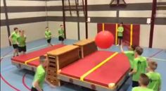 some kids are playing on a trampoline in a gym