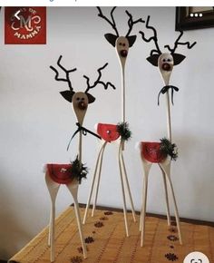 three wooden sticks with fake reindeer heads on them, one is red and the other is white