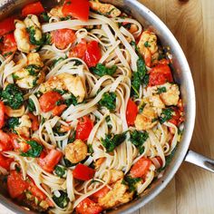 a pan filled with pasta and vegetables on top of a wooden table