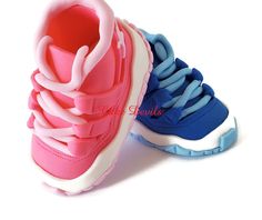 two pairs of shoes with pink, blue and white laces on the soles