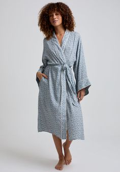 The charming Corina robe is cut from our inimitable cotton and adorned with an interesting blue Ditsy floral print. This oversized kimono-inspired robe boasts fluted sleeves and a detachable belt, creating a flattering silhouette. Contrast piping on the cuff and neck, complete this effortlessly feminine piece.    Cool machine wash only. Wash inside out and with similar colours 100% Cotton Modal   Cool machine wash only. Wash inside out and with similar colours Blue Floral Print Relaxed Fit Sleepwear, Blue Floral Print Sleepwear For Home, Blue Spring Robe For Loungewear, Spring Cotton Robe With Floral Print, Cotton Floral Print Robe For Daywear, Blue Summer Robe For Daywear, Blue Long Sleeve Robe For Spring, Blue Robe For Spring Daywear, Long Sleeve Blue Robe For Spring