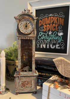 an old grandfather clock sitting on top of a table next to candles and other items