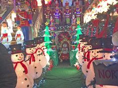 christmas decorations and lights decorate the inside of a house with snowmen on display in front