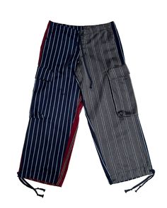 Make a bold statement with our Mixed Prep Stripe Wide Leg Pant - Multi, a creative and fun design that stands out from the crowd. These pants feature contrasting multi-color stripes—one side in vibrant red and white, while the other sides have blends navy blue, charcoal grey, and white for a unique look. The wide-leg cut and loose fit offer all-day comfort, complete with adjustable drawstrings and a button-up closure for a customizable fit. Cargo pockets on both sides add a practical touch, making these pants both stylish and functional. Whether you're dressing for everyday wear or a special occasion, these pants are the perfect mix of bold and laid-back. Pair them with our plaid shirts, Oliver jackets, or cotton button-up GL shirts for a complete, polished look that’s sure to turn heads. Unique Pants, Striped Wide Leg Pants, Plaid Shirts, Puffy Coat, Wide Leg Pant, Fun Design, Color Stripes, Polished Look, Vibrant Red