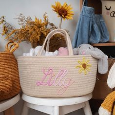 a stuffed bunny sitting next to a basket with personalized items in it on a chair