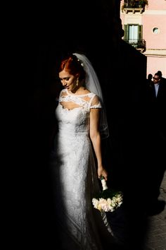 a woman in a wedding dress holding a bouquet