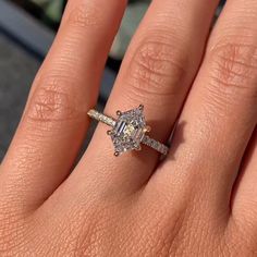 a woman's hand with an engagement ring on it and a diamond in the middle