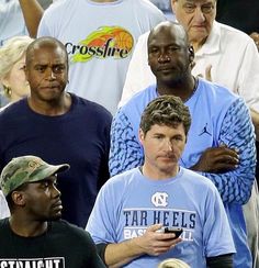 a group of men standing next to each other in front of a man holding a cell phone