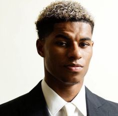 a young man in a suit and tie looking at the camera with a serious look on his face