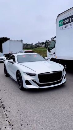 a white sports car is parked in front of a semi - truck on the road