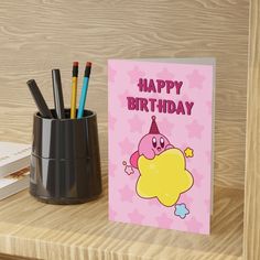 a birthday card sitting on top of a desk next to a cup with pencils in it