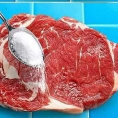 a piece of raw meat being gravy with a measuring spoon on the side