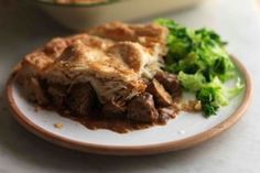 a piece of pie and some broccoli on a plate