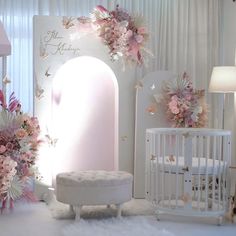 a baby's room decorated in pink and white with flowers on the wall, crib