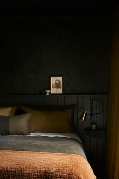 a bed in a dark room with two pictures on the wall