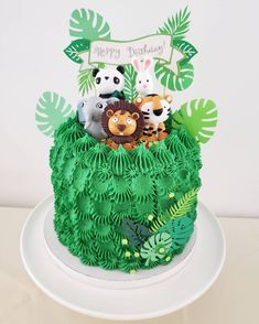 a birthday cake decorated with animals and plants