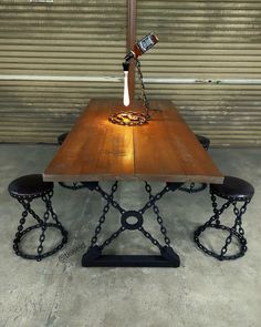 a wooden table with two benches and a lamp on it in front of a garage door