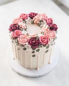 a white cake with pink and red flowers on top