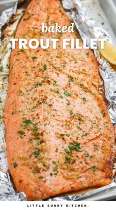 baked salmon fillet in foil with lemon wedges