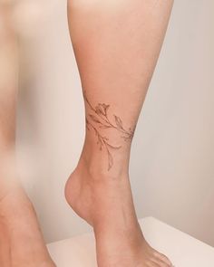 a woman's foot with a small tattoo on the side of her leg,