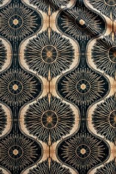 an image of a black and tan fabric with circles in the center, on top of it