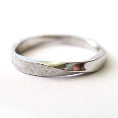 a close up of a silver ring on a white surface