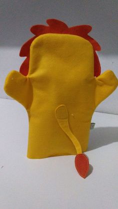 a yellow stuffed animal with a red heart attached to it's ear and tail