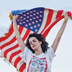 a woman holding an american flag in her hands