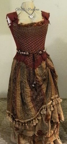 a mannequin is dressed up in an old fashion dress with ruffles and beads