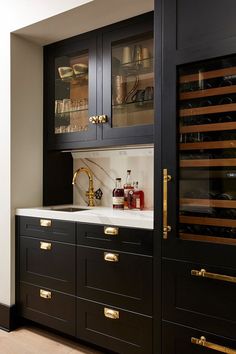 a kitchen with black cabinets and gold handles