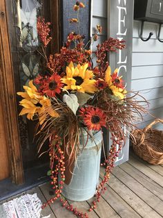 a vase filled with sunflowers and berries sitting on a wooden floor next to a door