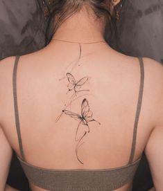 a woman with a butterfly tattoo on her back