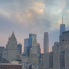 the city skyline is shown with skyscrapers in the foreground and clouds in the background