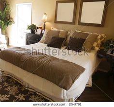 a large bed in a bedroom with two framed pictures on the wall