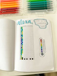 an open planner book with colored pencils and markers on the pages next to it