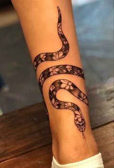 a woman's foot with a tattoo on it and a snake on the side