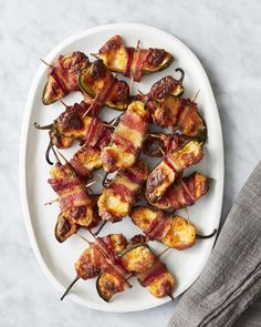 bacon wrapped jalapenos on a white plate