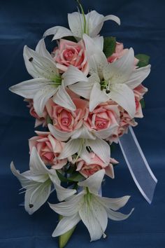 a bridal bouquet with pink roses and white lilies on a dark blue background