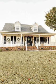 a white house with wreaths on the front porch