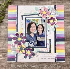 two women are smiling and posing for the camera in front of a card with flowers on it