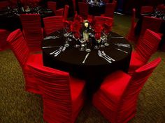 a black table topped with red chairs covered in flowers