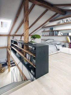 an attic bedroom with wooden beams and shelves on the wall, along with bookshelves